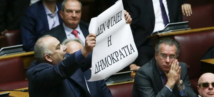 Ο Σαρίδης σήκωσε πανό στη Βουλή – «Δεν φταίει η Δημοκρατία» (Εικόνα)